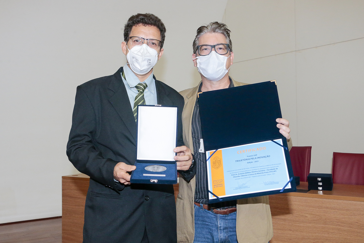 O diretor da FFLCRP, Marcelo Mulato, entregou o prêmio ao homenageado Antonio Adilton Oliveira Carneiro (à esquerda) – Foto: Marcos Santos/USP Imagens