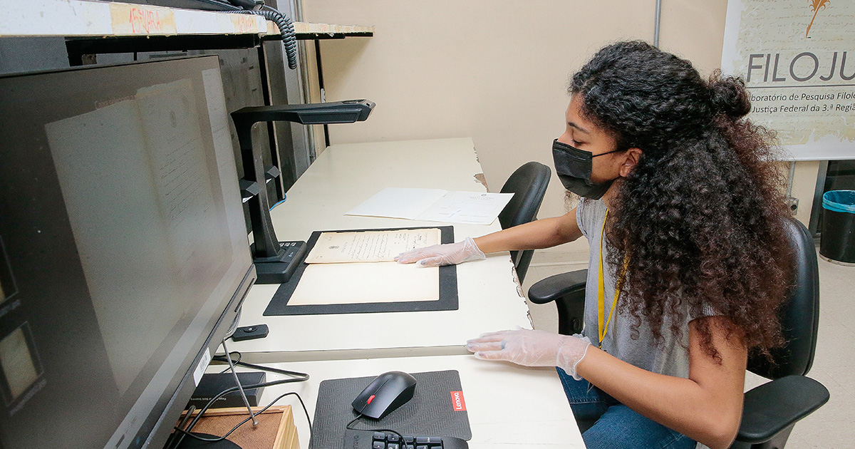 Alice Bispo, estagiária da Justiça Federal e estudante de Letras, escaneia documento no laboratório - Foto: Marcos Santos/USP Imagens