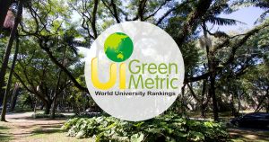 Na imagem tem uma área verde ao fundo, com árvores e em primeiro plano um selo com a inscrição UI GreenMetric Word University Rankings