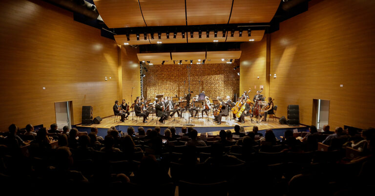 Uma orquestra tocando música num palco.