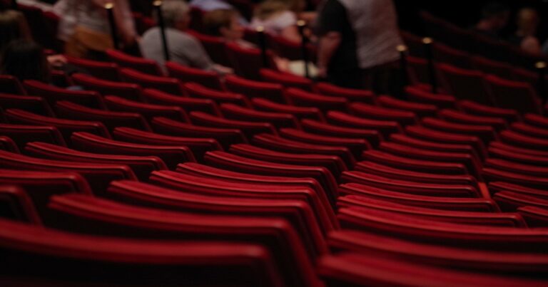 assentos vermelhos de auditório visto por traz