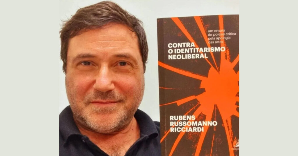 Homem branco com imagem da capa de um livro ao lado