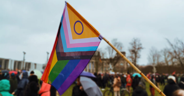 Imagem: Bandeira com as cores LGBT em meio a manifestação