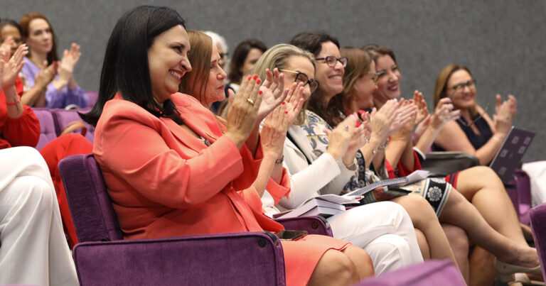 Imagem: Mulheres, em um auditório, aplaudindo