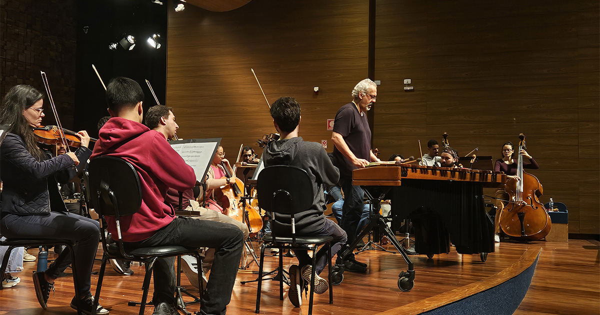 Jovens tocando instrumentos num palco.