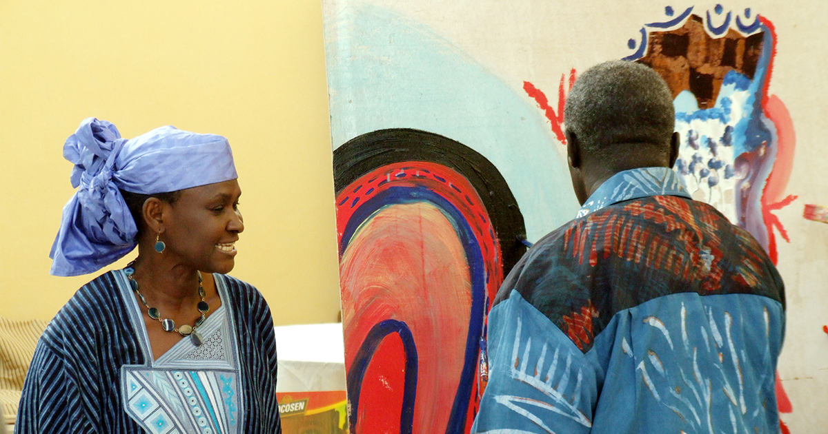 Imagem: Mulher negra africana usando um turbante e homem de costas usando uma camisa colorida