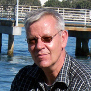 Foto do pesquisador Martin Andreas Metzger, um homem branco, cabelos grisalhos de óculos escuros redondo. Usa uma camisa xadrez preta e branca.