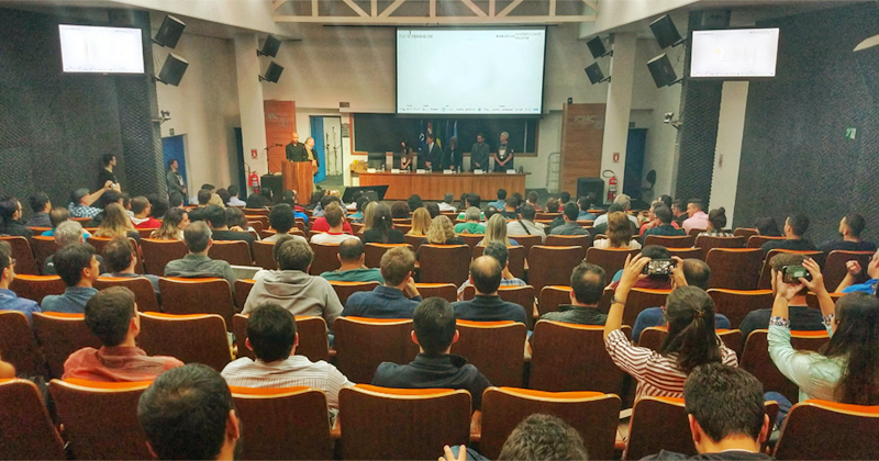 Auditório com pessoas vendo uma palestra