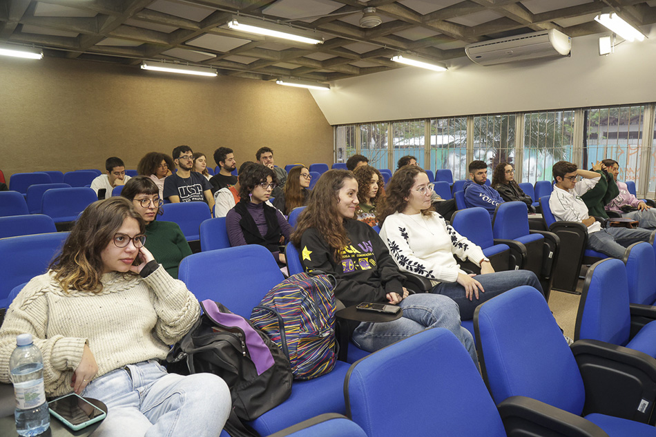 vários jovens em um auditório de cadeiras azuis