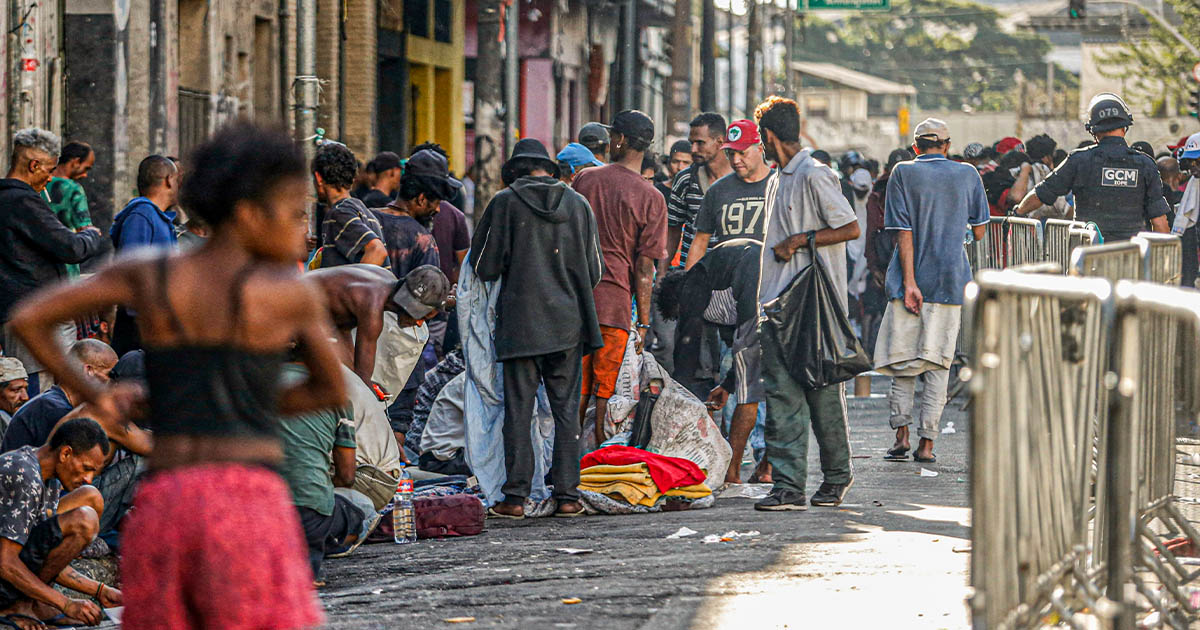 Imagem de pessoas amontoadas num trecho de rua, muitas delas aparentando serem deserdadas da sorte