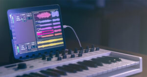 Teclado musical e tablet em uma produção musical de sala escura