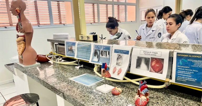 Grupo de estudantes de enfermagem numa bancada de laboratório