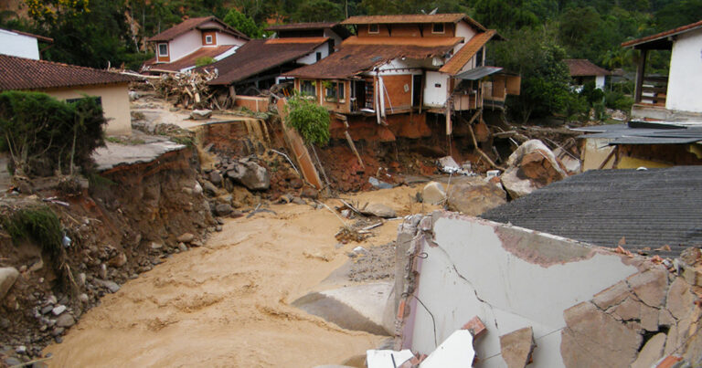 Um barranco e pedaços de construção na lama, onde ocorreram deslizamentos