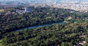 Imagem aérea do campus da USP em Ribeirão Preto, com o lago em destaque e o Hospital das Clínicas ao fundo.