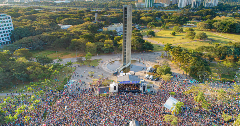 Visão aérea da Praça do Relógio na USP com palco e público vendo um show