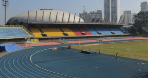 Close de uma área de um estádio com pista de atletismo e arquibancada