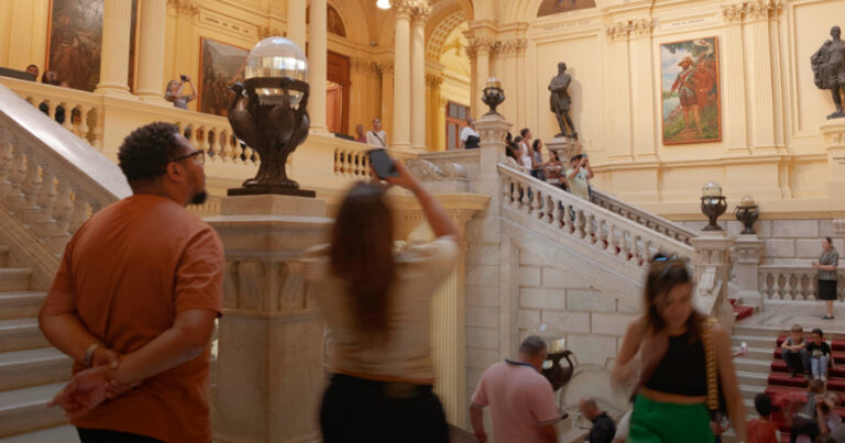 Pessoas tirando fotos e circulando num museu