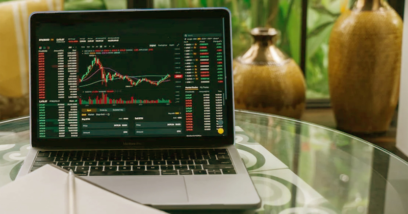 Notebook numa mesa mostrando na tela gráficos de investimentos