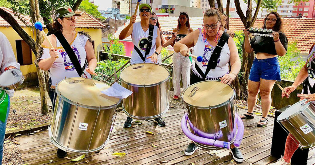 Desfile de um bloco de carnaval numa rua.