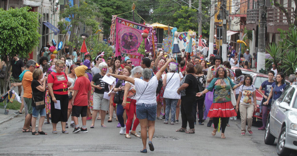 Desfile de um bloco de carnaval numa rua.