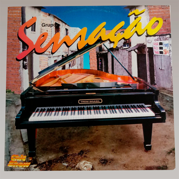 Capa de disco do grupo Sensação, com o nome do grupo escrito em letra cursiva no topo da imagem; no centro, um piano de calda aberta em uma viela de chão batido. Em volta, casas de alvenaria de blocos à mostra