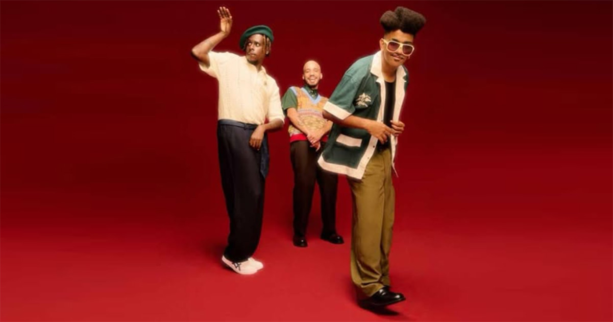 Foto de três homens negros em um fundo vermelho
